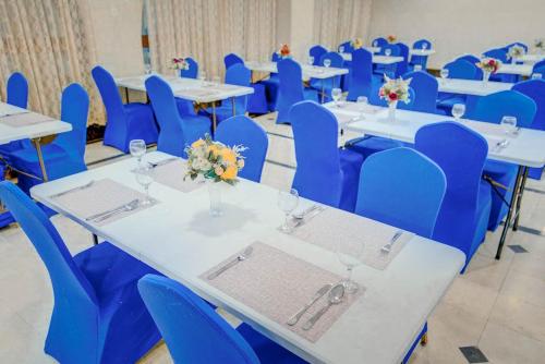 Hayah Grand Hotel في المدينة المنورة: غرفة مليئة بالطاولات والكراسي الزرقاء