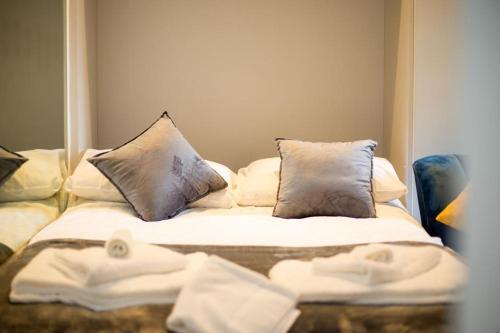 Bett mit weißer Bettwäsche und Kissen in einem Zimmer in der Unterkunft Charming studio in London