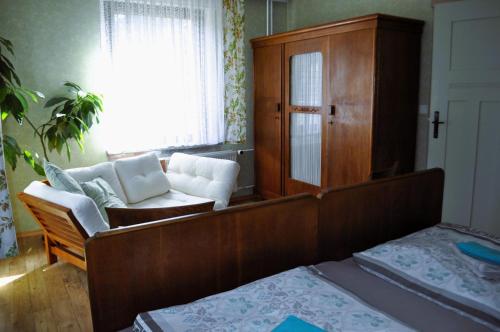 ein Wohnzimmer mit einem Sofa und einem Stuhl in der Unterkunft Historische Ferienwohnung für bis 5 Personen in Spremberg