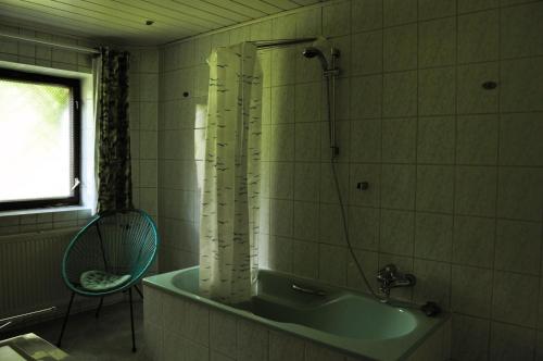 ein Bad mit einer Badewanne, einem Stuhl und einem Fenster in der Unterkunft Historische Ferienwohnung für bis 5 Personen in Spremberg