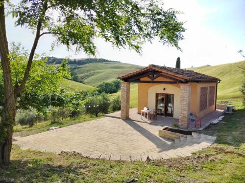 a small house with a patio in a field at Agriturismo Podere Campaini in Volterra
