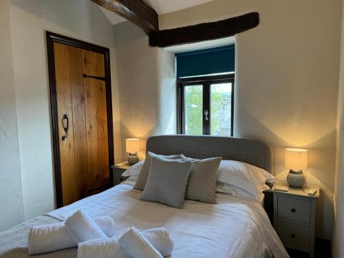una camera da letto con un letto con cuscini bianchi e una finestra di Number Three, Yard 12 Kendal a Kendal