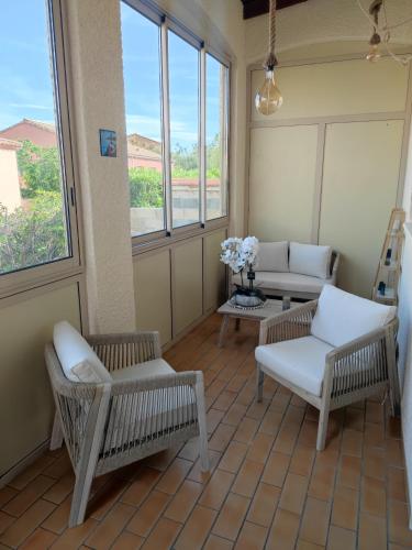 un salon avec deux chaises et une table dans l'établissement La Villa Marcel, au Barcarès