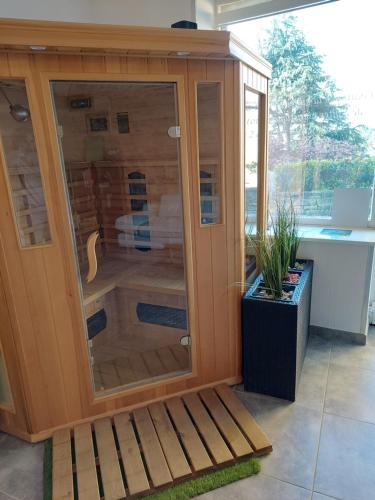a wooden shower with a glass door in a room at Appartement Jarnioux - Les Meublés des Pierres Dorées in Theizé