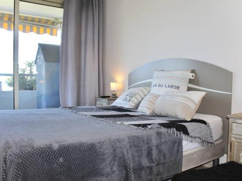 une chambre avec un lit avec des oreillers et une fenêtre dans l'établissement Appartement moderne 48m² avec terrasse, 4 couchages, climatisé - Villeneuve-Loubet Plage - FR-1-252A-123, à Villeneuve-Loubet