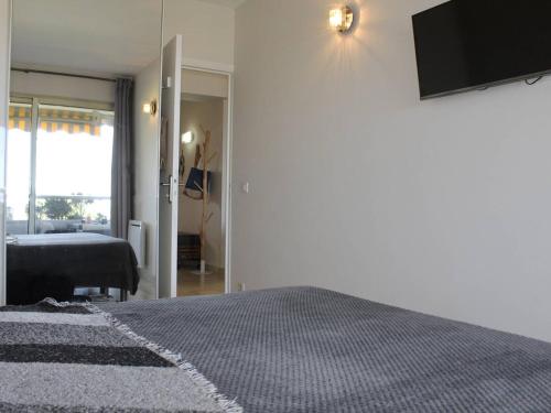 une chambre avec un lit et une télévision sur un mur dans l'établissement Appartement moderne 48m² avec terrasse, 4 couchages, climatisé - Villeneuve-Loubet Plage - FR-1-252A-123, à Villeneuve-Loubet