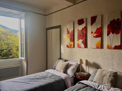 une chambre avec deux lits et une fenêtre dans l'établissement Gîte de l'Olivier, à Nyons