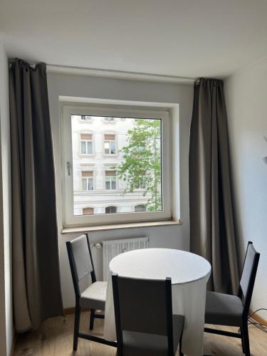 mesa y sillas en una habitación con ventana en Düs Apartment 1, en Düsseldorf