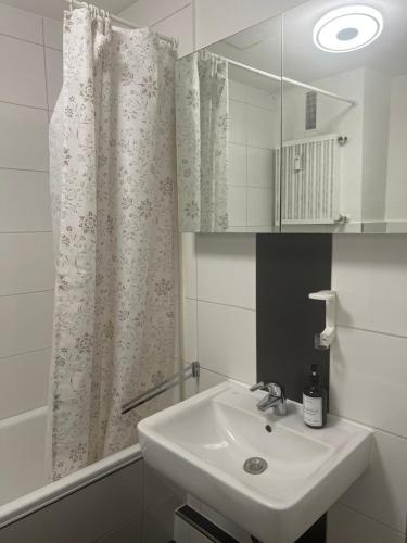 baño con lavabo y cortina de ducha en Düs Apartment 1, en Düsseldorf