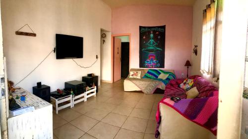 a living room with a couch and a tv at Hospedaria Dos Astros in São Thomé das Letras