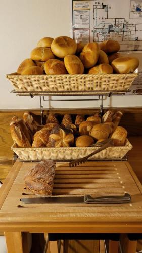 a bunch of loaves of bread in baskets on a table at Hotel Löwen in Reit im Winkl
