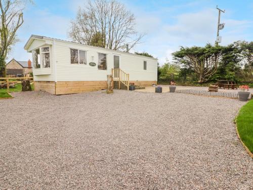 a house with a gravel driveway in front of it at Grandads Shack in Pontypool