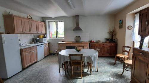 une cuisine avec une table et un chiffon de table blanc dans l'établissement La ferme d'Yvette et Zou, au coeur des Baronnies Provencales, pour un séjour en famille ou entre amis, à Barret-sur-Meouge