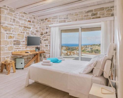 a bedroom with a large bed and a stone wall at Brand new comfortable villa Ganesha In Pitsidia, Matala ,Kalamaki in Pitsidia