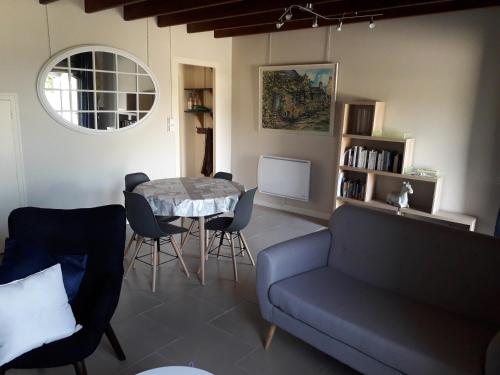 un salon avec un canapé, une table et des chaises dans l'établissement La luzerne, à Saint-Martin-le-Hébert