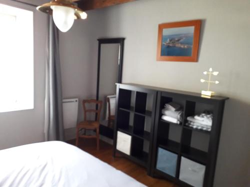 - une chambre avec une étagère noire et un lit dans l'établissement La luzerne, à Saint-Martin-le-Hébert