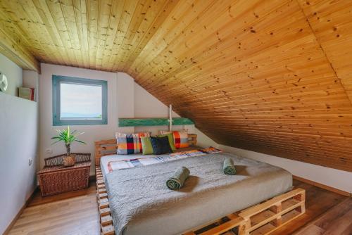 una camera con un grande letto e un soffitto in legno di HillSide Gasthaus 2 a Szent György-hegy lankáin a Tapolca