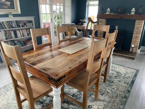 uma mesa de madeira com cadeiras e uma sala de jantar em Wild Atlantic View em Sligo