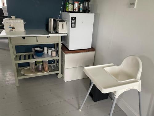 a kitchen with a white refrigerator and a white chair at Wild Atlantic View in Sligo