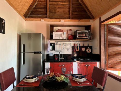 a kitchen with a table and a refrigerator at Divina Cabana - Lago Corumbá IV - Alexânia in Alexânia