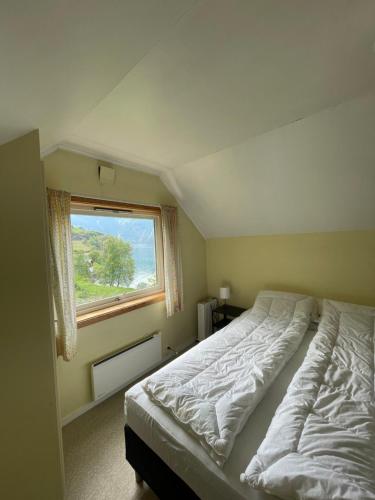 a bedroom with a large bed and a window at Aurland Feriehus in Aurland