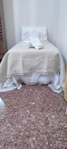 a bedroom with a bed with white sheets on it at Maison Canopée in Messina