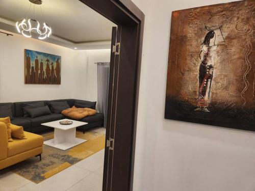salon z kanapą i obrazem na ścianie w obiekcie Oasis w mieście Dakar