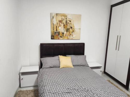 sypialnia z łóżkiem i obrazem na ścianie w obiekcie Oasis w mieście Dakar