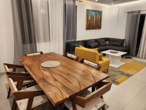 salon z drewnianym stołem i kanapą w obiekcie Oasis w mieście Dakar