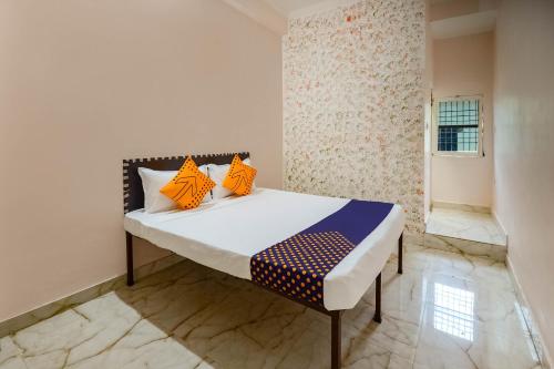 Schlafzimmer mit einem Bett mit orangefarbenen und blauen Kissen in der Unterkunft SPOT ON 66974 Hotel shri gurukripa in Gwalior