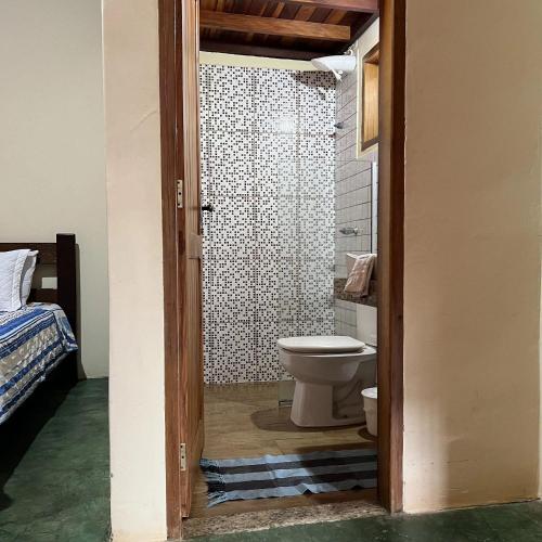 a bathroom with a toilet and a shower at Pousada Recanto Janbor in Olímpia