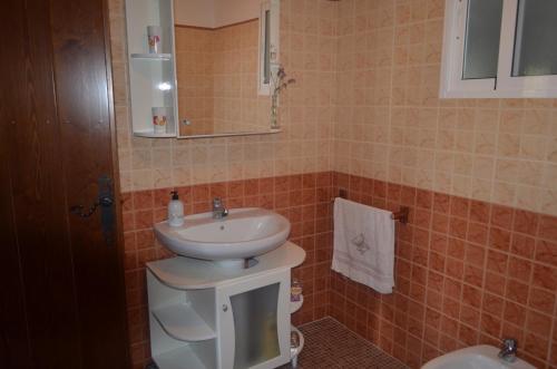 a bathroom with a sink and a mirror and a toilet at La Laguna in Almedinilla