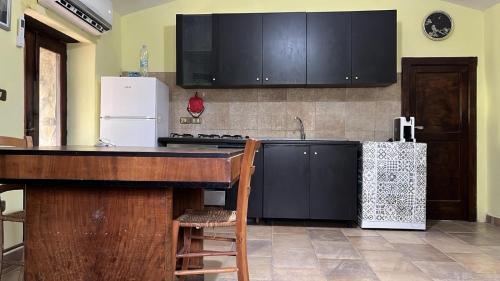 a kitchen with black cabinets and a white refrigerator at A casa di Giovanni apartment in Albano di Lucania