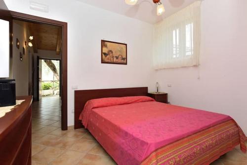 a bedroom with a large bed with a pink blanket at Casa Vacanze Dalisa Ulivo A con parcheggio in Tramonti