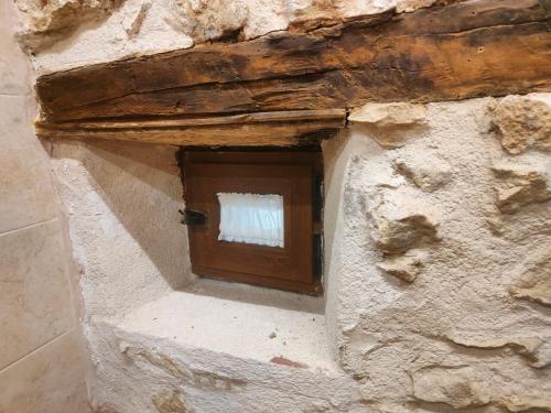 a door in a stone wall with a window at Matandrino in Prádena