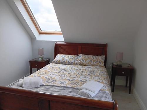 ein Schlafzimmer mit einem Bett mit zwei Nachttischen und einem Fenster in der Unterkunft Duplex/2 Bedrooms on Kildare/Carlow/Laois Border in Carlow