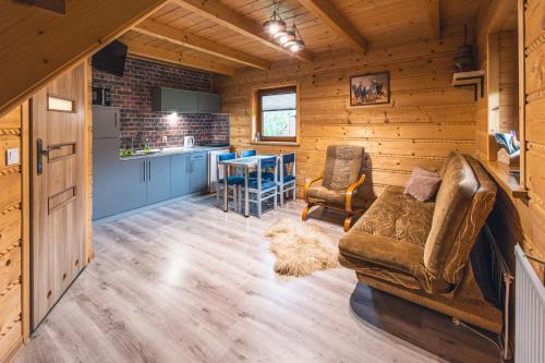 uma cozinha e sala de estar num chalé de madeira em Domek na Leśnej em Comuna de Łapsze Niżne