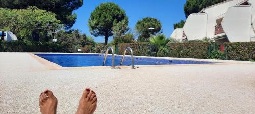une personne debout à côté d'une piscine dans l'établissement Green Village - Entre nature et mer, à La Grande Motte
