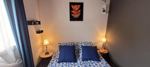 - une petite chambre avec 2 oreillers bleus sur un lit dans l'établissement Green Village - Entre nature et mer, à La Grande Motte