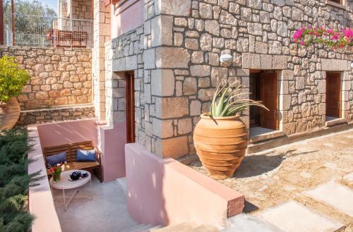a vase with a plant in it next to a building at PYRGOS RALLI ESTATE Guesthouse in Aegina Town