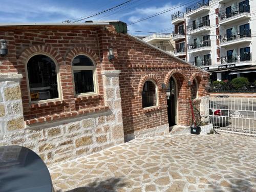 a brick building with windows on the side of it at Hotel Arsenal in Ksamil