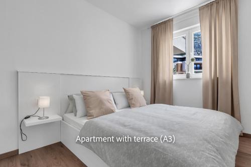 a white bedroom with a bed and a window at La Mer Adriatique in Makarska