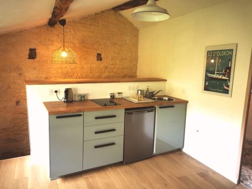 a kitchen with a sink and a counter top at Les chambres de Cherveux in Cherveux
