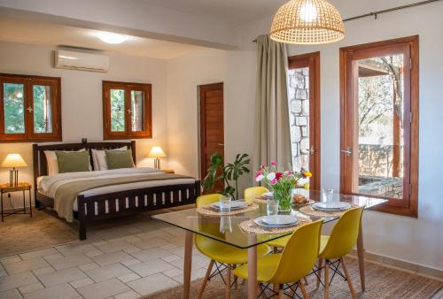 a bedroom with a bed and a table and chairs at PYRGOS RALLI ESTATE Guesthouse in Aegina Town