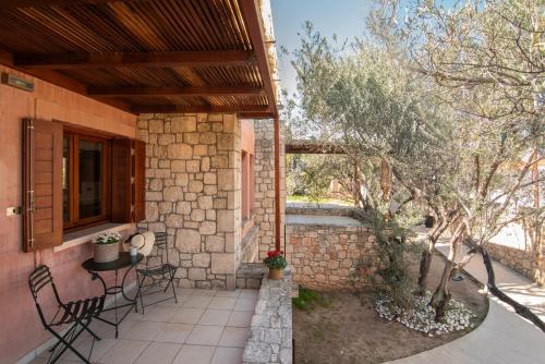 a patio with a table and chairs on a house at PYRGOS RALLI ESTATE Guesthouse in Aegina Town