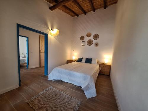 Un dormitorio con una cama y dos luces en la pared. en Typical house in Algarve 5m from beach, en Porches