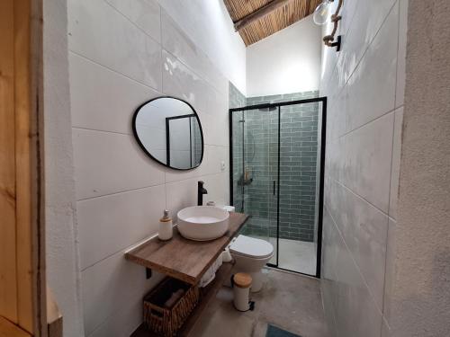 Un baño con lavabo, espejo e inodoro. en Typical house in Algarve 5m from beach, en Porches