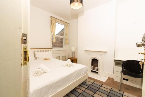 a white bedroom with a bed and a fireplace at Suite 3 - Trendy Private Room near City Centre in Manchester
