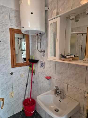 a bathroom with a sink and a red bucket at Lovely 2-bedroom apartment in Novi Vinodolski in Novi Vinodolski