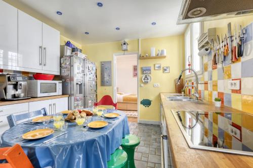 une cuisine avec une table bleue et de la nourriture. dans l'établissement Large Duplex Flat in a Courtyard - Trendy Paris 10, à Paris